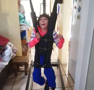 Niño de pie con su arnés