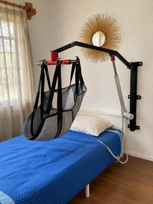 Grúa de pared instalada junto a una cama