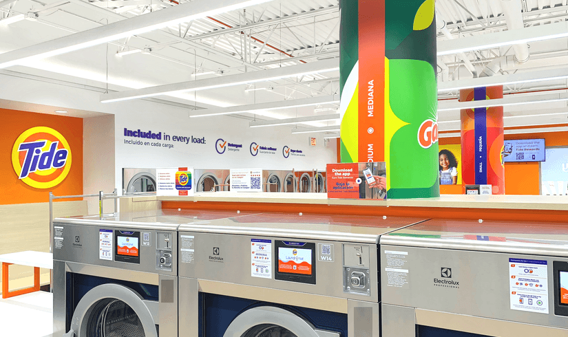 Tide Laundromat folding tables, dryers, and Tide wall.