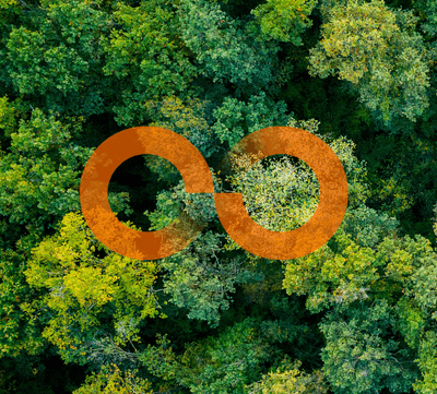 Luchtfoto van een dicht bos met een oranje oneindigheidssymbool, representatief voor duurzaamheid en circulaire economie.