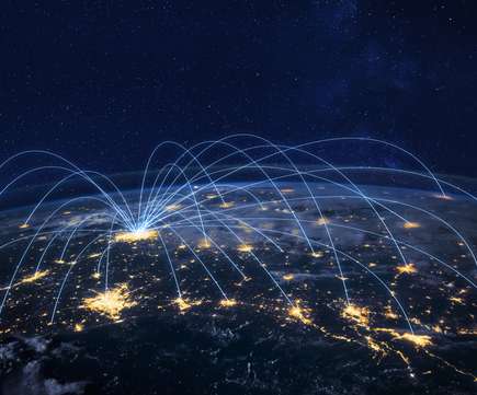 Luchtfoto van de aarde bij nacht met lichtpunten die verbonden zijn door blauwe lijnen, symboliserend wereldwijde connectiviteit en dataverkeer.