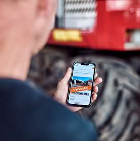 Een afbeelding van een man die een mobile telefoon in handen heeft waarop de melding "verkocht" staat. Dit illustreert een succesvol verkochte kavel.